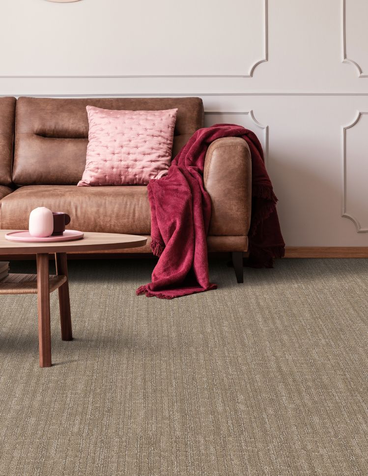 textured brown carpets in a Switz City living room with brown leather couch and pink accents